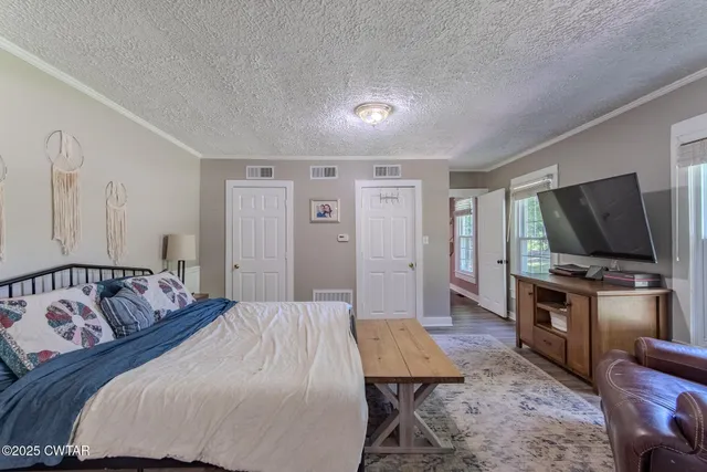 a bedroom with a bed and a flat screen tv