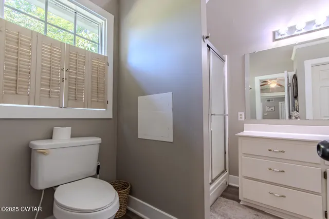 a bathroom with a toilet a sink a vanity and windows