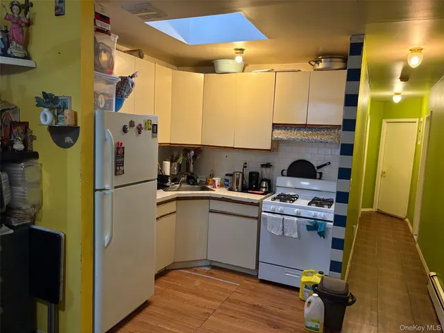 a kitchen with a refrigerator and wooden floor