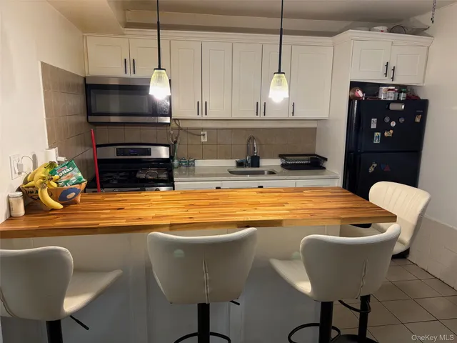 a kitchen with stainless steel appliances granite countertop a sink a microwave and a refrigerator