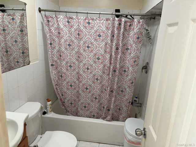 a white toilet sitting next to a shower curtain