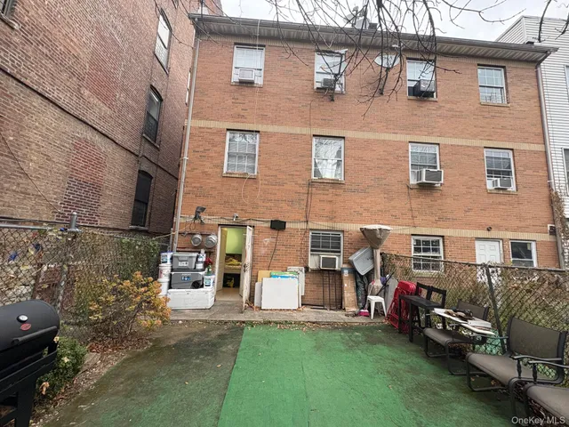 a view of a brick house with many windows and a yard