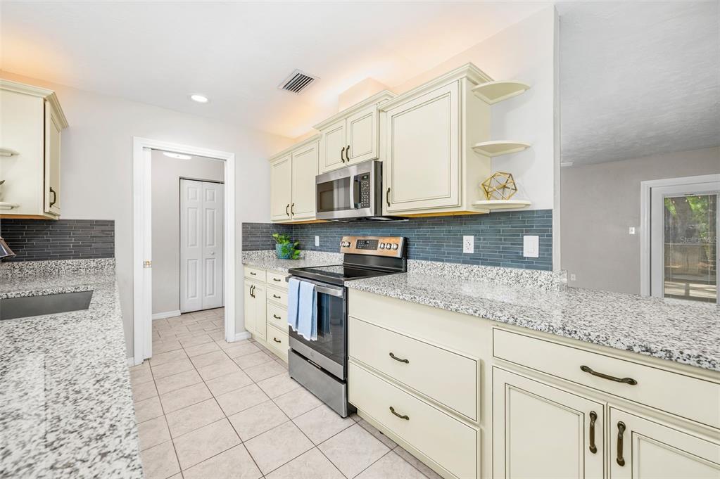 6820 Southwest 78th Street Gainesville, FL 32608 - Photo 11 of 41 a kitchen with stainless steel appliances granite countertop a stove a sink and a microwave