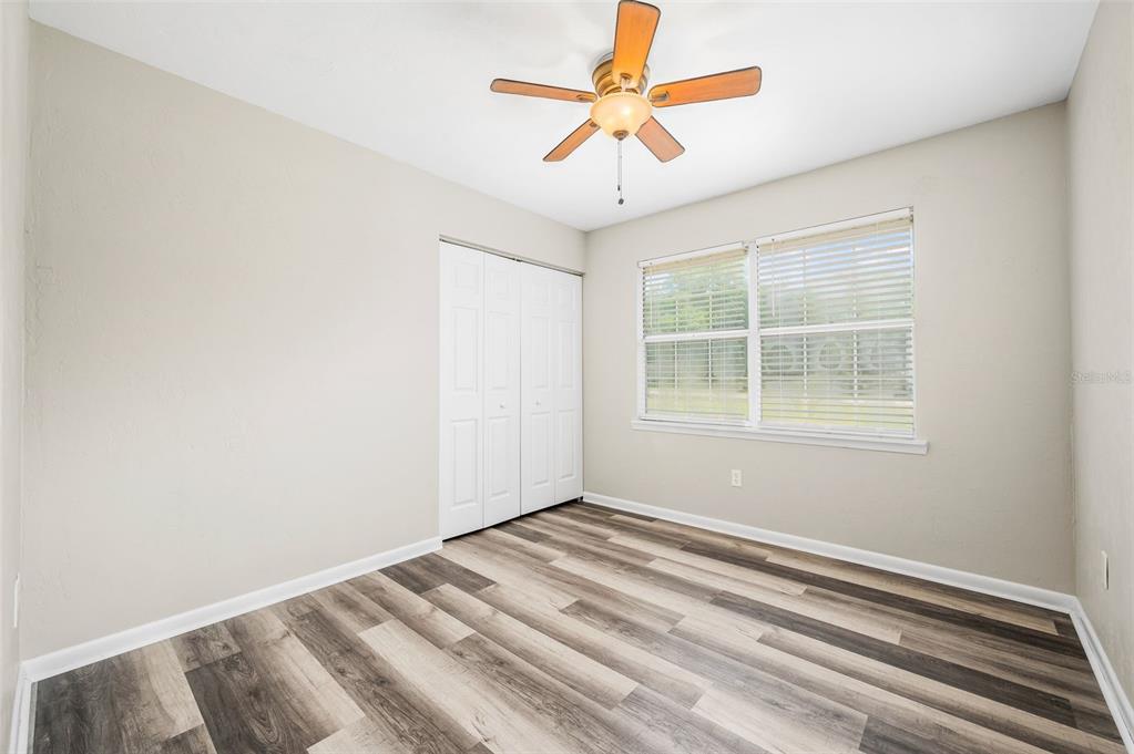 6820 Southwest 78th Street Gainesville, FL 32608 - Photo 22 of 41 an empty room with a window and a ceiling fan