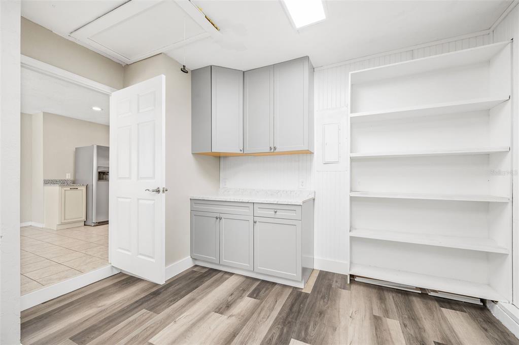 6820 Southwest 78th Street Gainesville, FL 32608 - Photo 26 of 41 a view of a kitchen with white cabinets and wooden floor