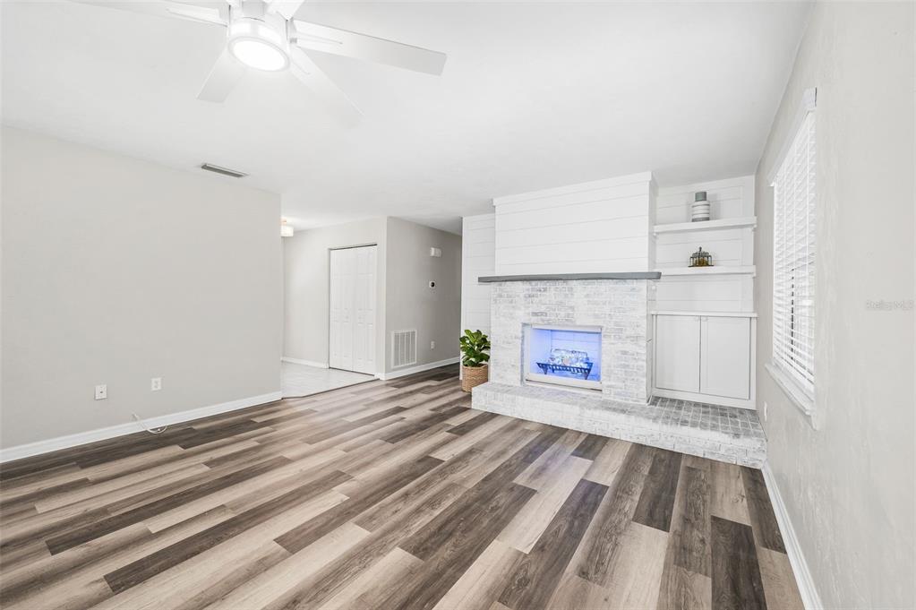 6820 Southwest 78th Street Gainesville, FL 32608 - Photo 6 of 41 a view of an empty room with wooden floor and a fireplace
