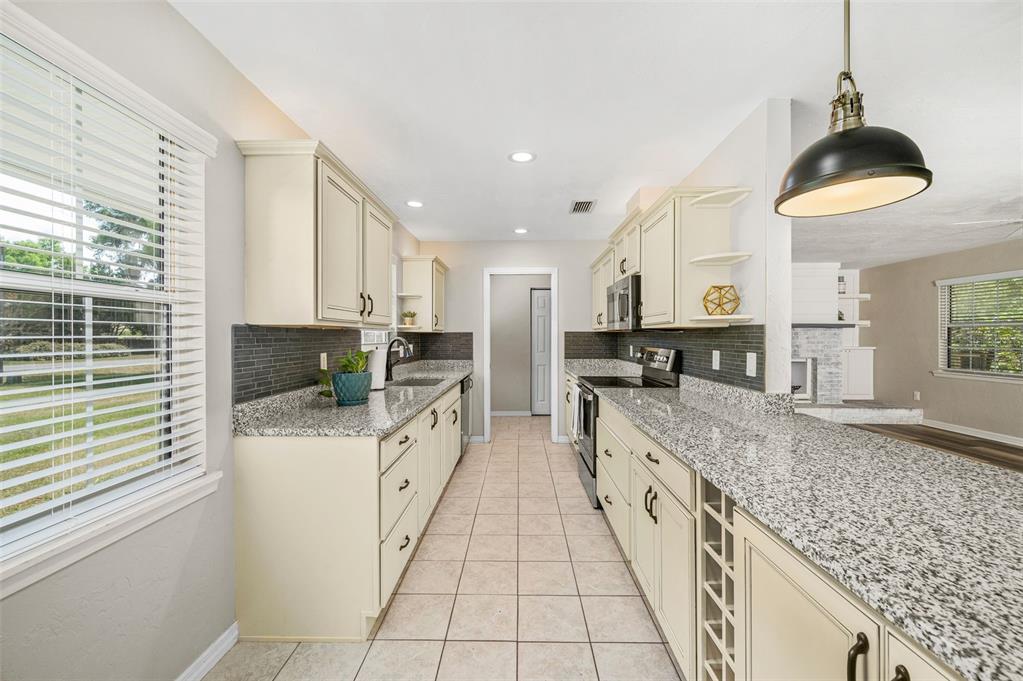 6820 Southwest 78th Street Gainesville, FL 32608 - Photo 9 of 41 a large kitchen with stainless steel appliances granite countertop a sink and cabinets