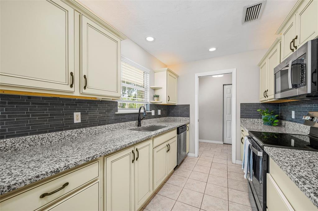 6820 Southwest 78th Street Gainesville, FL 32608 - Photo 10 of 41 a kitchen with stainless steel appliances granite countertop a sink and cabinets