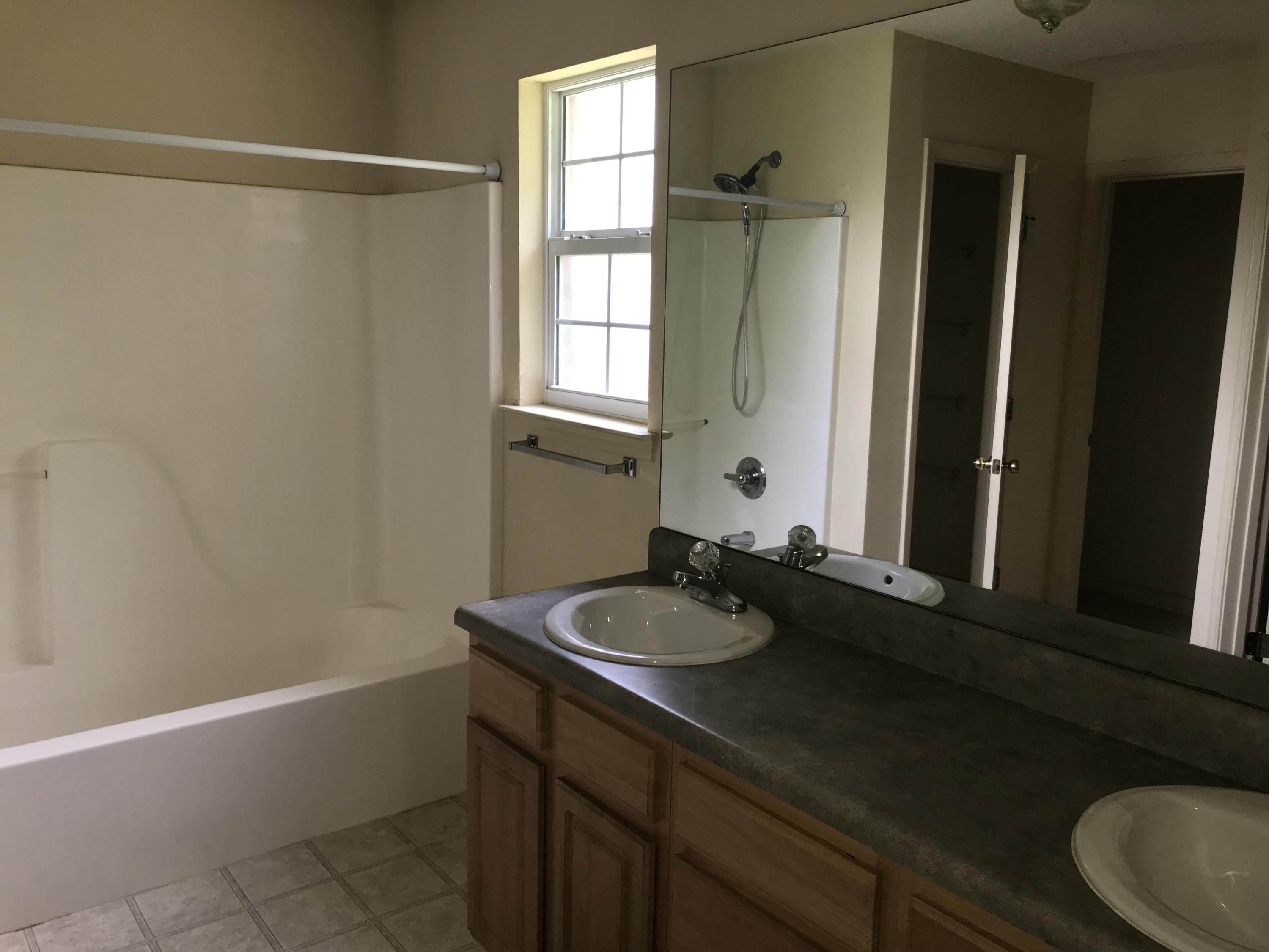 220 Tiffot Court Crestview, FL 32539 - Photo 8 of 15 a bathroom with a granite countertop sink and a mirror