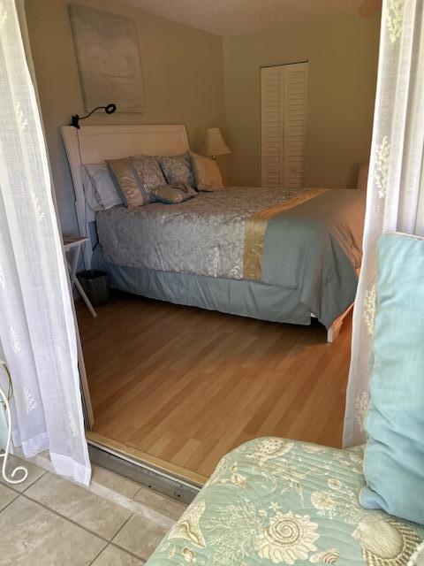 1955 Southwest Palm City Road, Unit H Stuart, FL 34994 - Photo 21 of 22 a bedroom with a bed and wooden floor