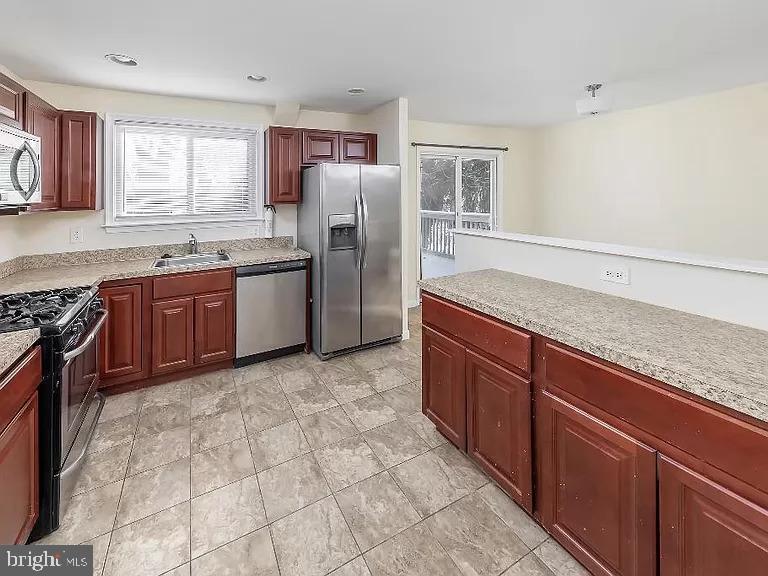 6 Cornell Road Glassboro, NJ 08028 - Photo 3 of 15 a kitchen with stainless steel appliances granite countertop a stove a sink dishwasher a refrigerator and a oven with wooden cabinets