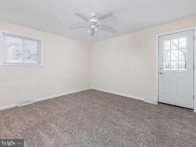 an empty room with a window and a ceiling fan