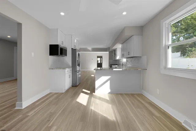 a view of a kitchen with wooden floor and a window