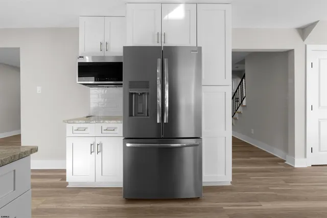 a view of empty room with wooden floor and fireplace
