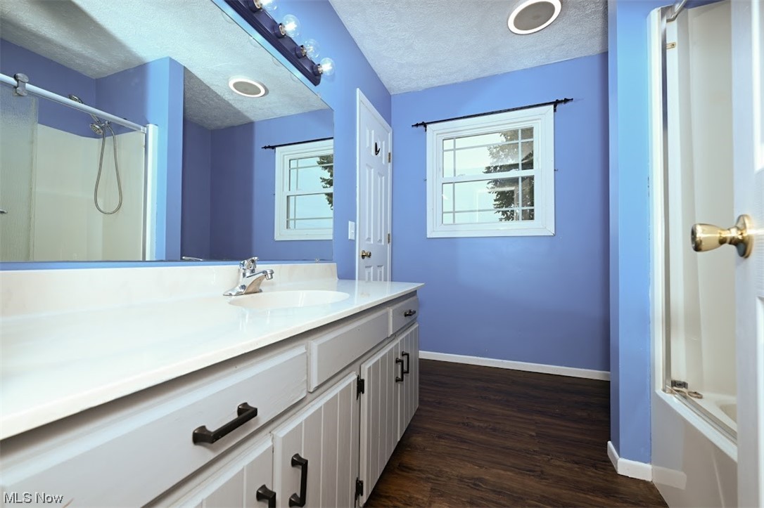 3368 Erhart Road Litchfield, OH 44253 - Photo 17 of 35 Bathroom featuring vanity, a textured ceiling, mirror, shower / bathing tub combination, and dark hardwood flooring