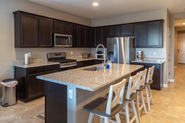 a kitchen with stainless steel appliances wooden cabinets a stove a sink and a microwave