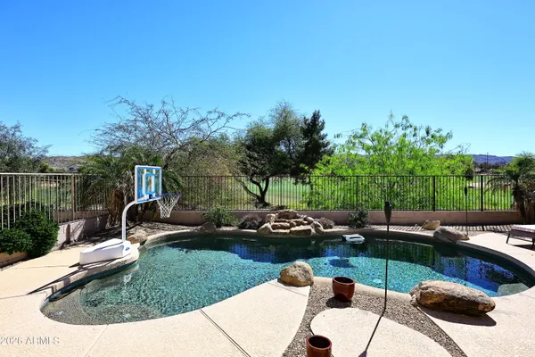 a view of a backyard with table and chairs potted plants and swimming pool