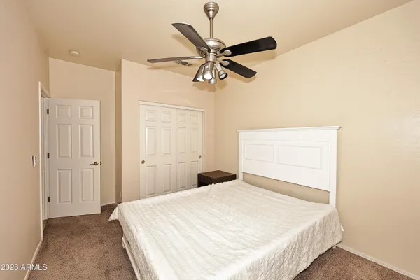a bedroom with a bed and a ceiling fan