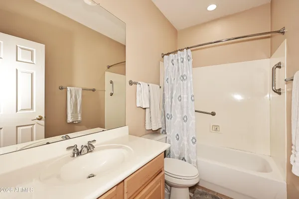a bathroom with a sink a toilet and a large mirror