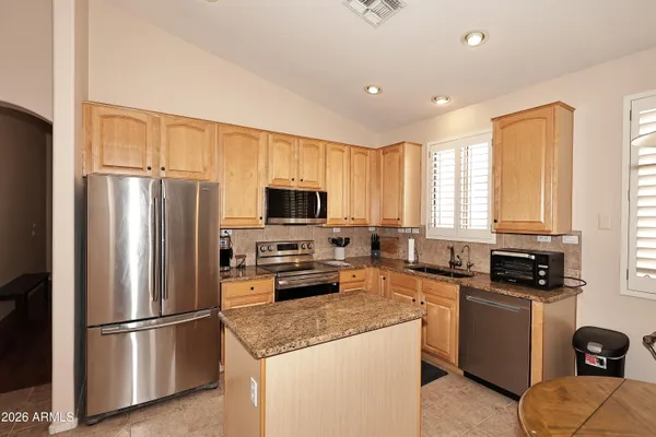 a kitchen with stainless steel appliances a refrigerator sink and microwave