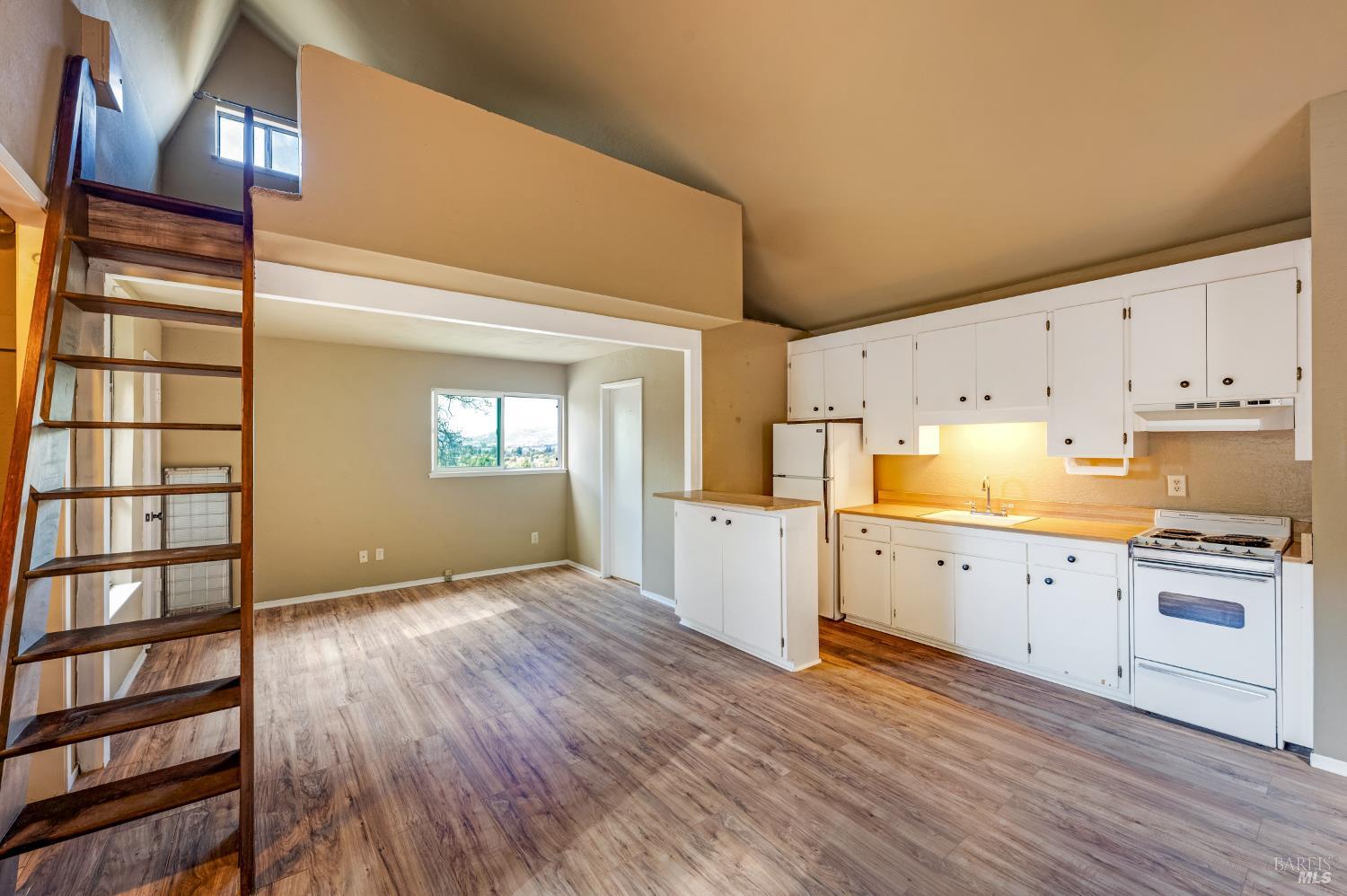 5550 Pepperwood Road Santa Rosa, CA 95409 - Photo 25 of 35 a kitchen with wooden floors and white cabinets