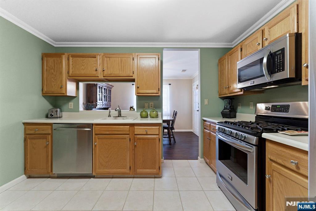 2309 Hemingway Lane, Unit 2309 Mahwah, NJ 07430 - Photo 5 of 28 a kitchen with stainless steel appliances granite countertop a stove top oven a sink dishwasher and white cabinets with wooden floor