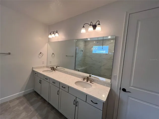 a bathroom with a double vanity sink and a mirror