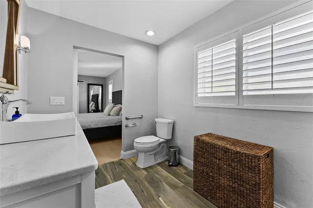 a bathroom with a granite countertop sink a toilet and shower