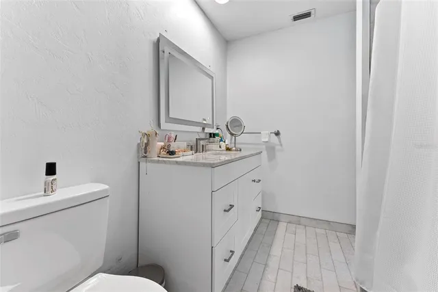 a view of a back yard with plants and large trees