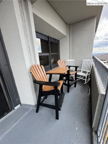 a balcony with chairs and a table