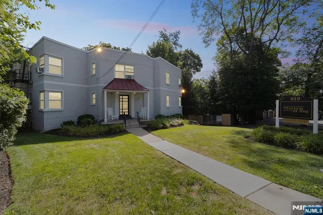 a front view of a house with yard and green space