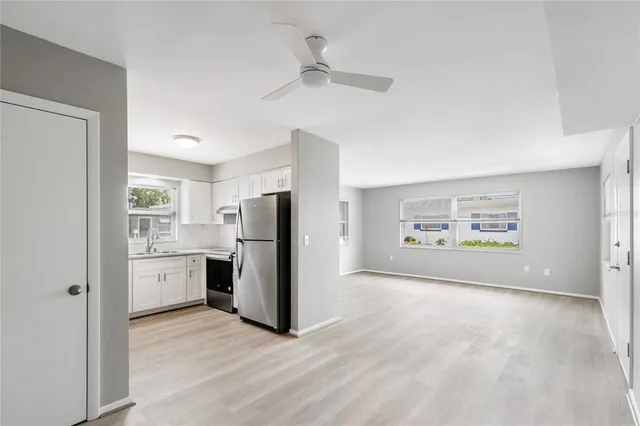 a view of a kitchen with refrigerator stove and wooden floor