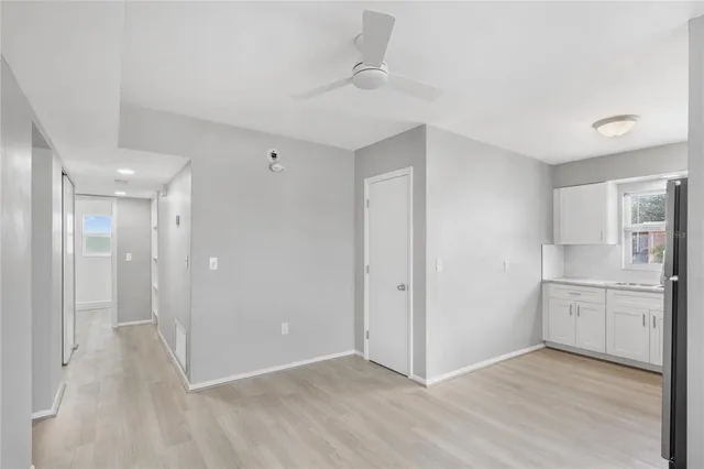 a view of an empty room with closet and a window