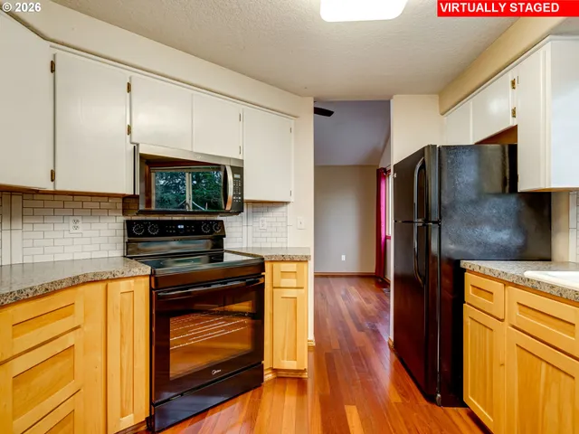 a kitchen with a refrigerator stove and wooden cabinets