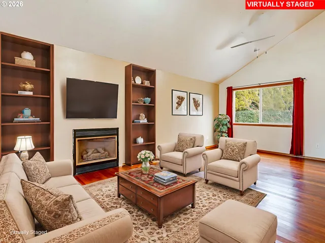 a living room with furniture a flat screen tv and a fireplace