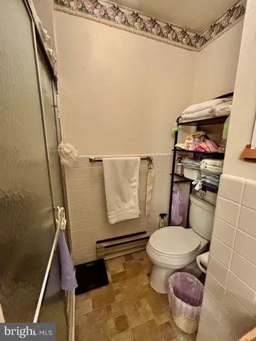 a bathroom with a toilet and a shower