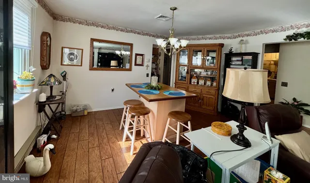 a view of a livingroom and dining room with furniture wooden floor and chandelier