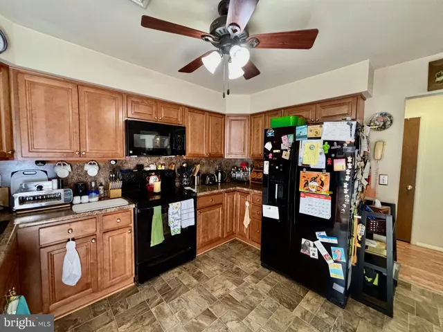 a kitchen with stainless steel appliances granite countertop a refrigerator stove top oven and sink
