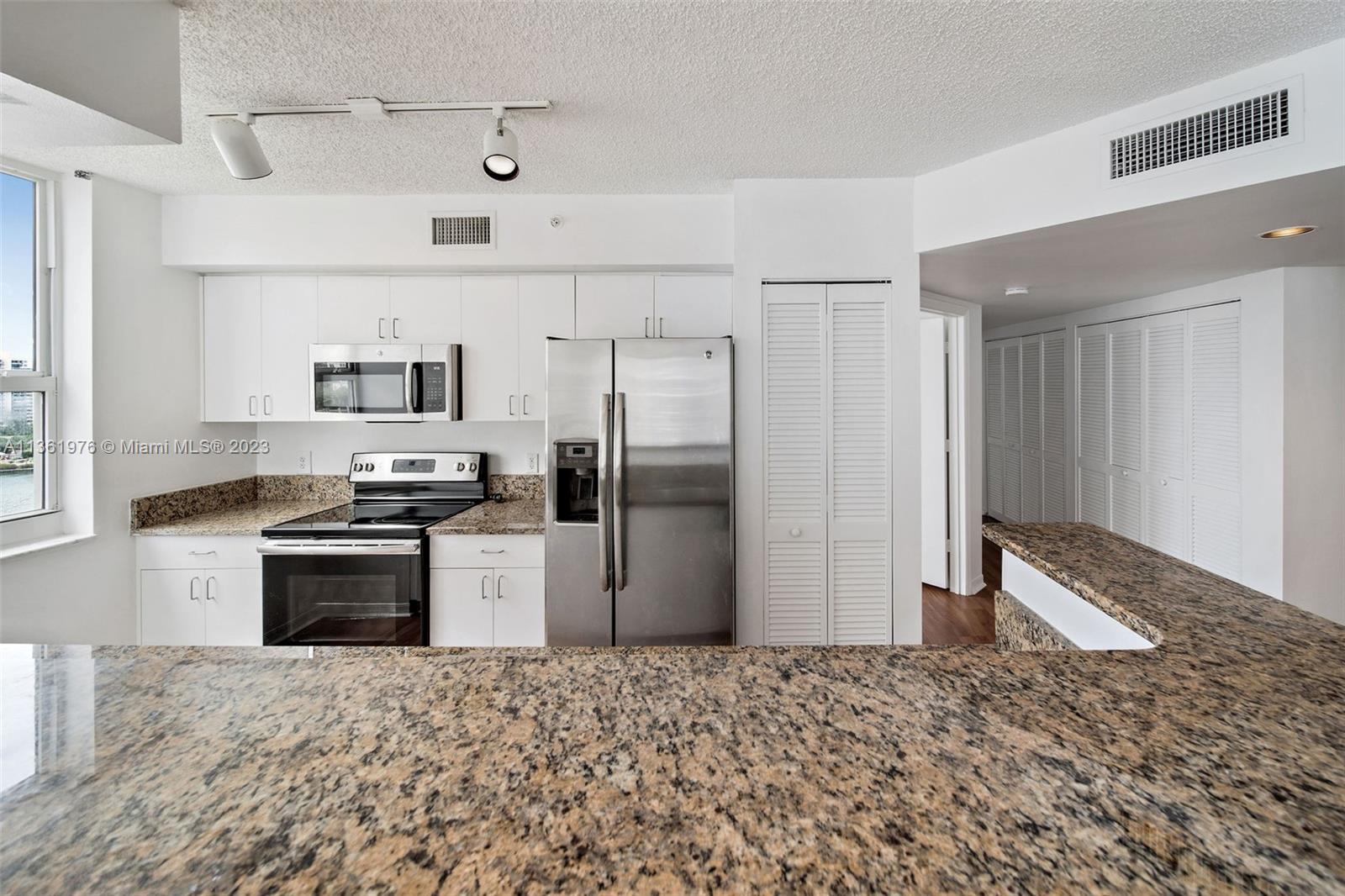1111 Brickell Bay Drive, Unit 1102 Miami, FL 33131 - Photo 13 of 72 a kitchen with stainless steel appliances granite countertop a refrigerator a stove and a sink