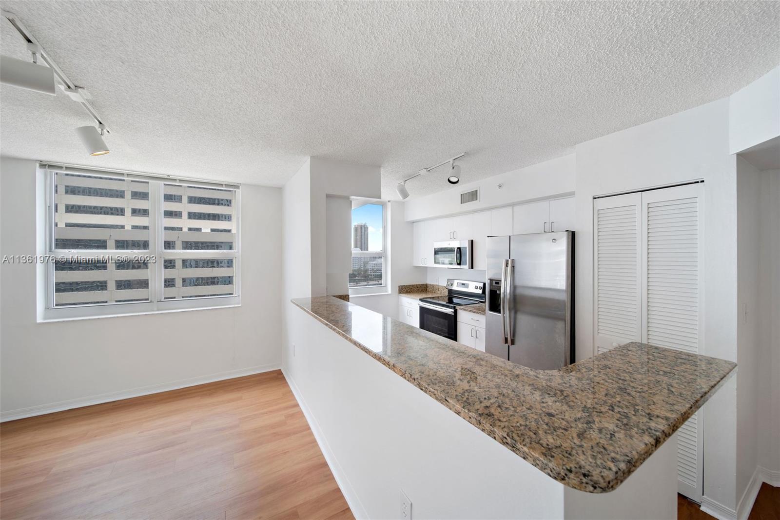 1111 Brickell Bay Drive, Unit 1102 Miami, FL 33131 - Photo 15 of 72 a kitchen with refrigerator and countertop