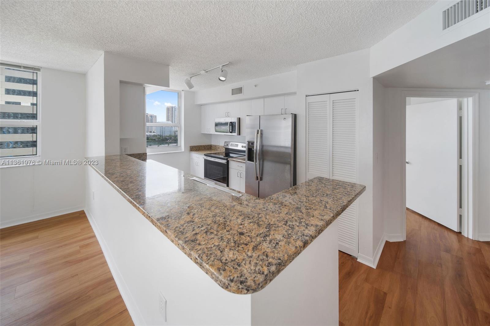 1111 Brickell Bay Drive, Unit 1102 Miami, FL 33131 - Photo 16 of 72 a kitchen with stainless steel appliances granite countertop a sink stove and refrigerator
