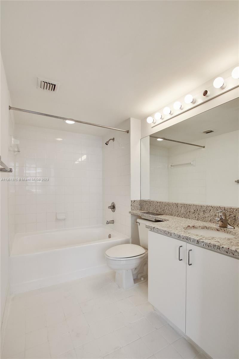 1111 Brickell Bay Drive, Unit 1102 Miami, FL 33131 - Photo 23 of 72 a bathroom with a granite countertop sink a toilet and shower