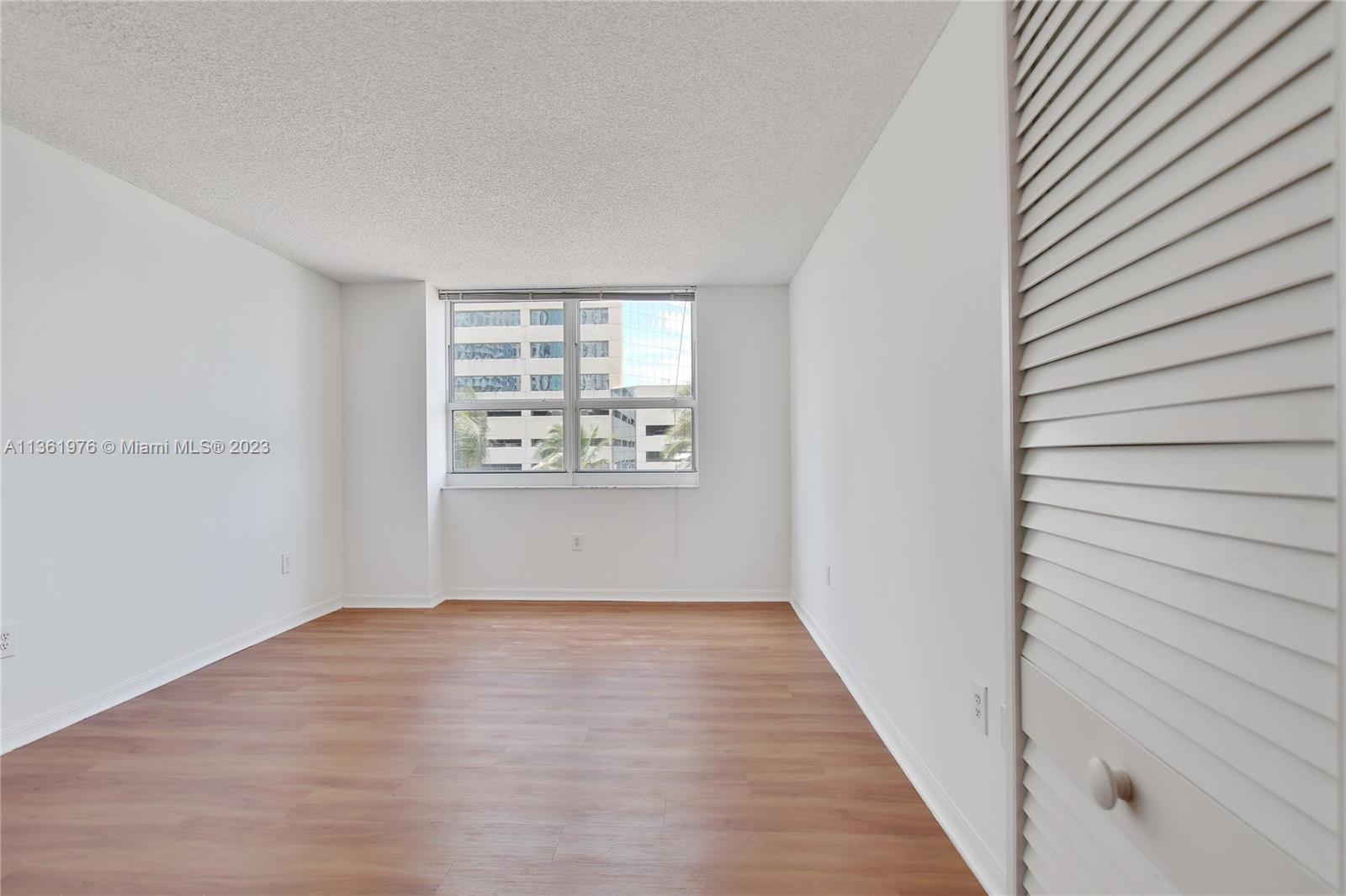 1111 Brickell Bay Drive, Unit 1102 Miami, FL 33131 - Photo 28 of 72 a view of an empty room with wooden floor