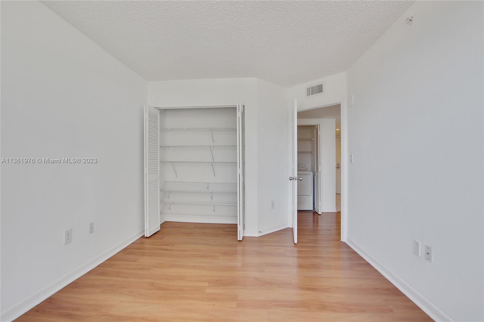 1111 Brickell Bay Drive, Unit 1102 Miami, FL 33131 - Photo 29 of 72 a view of an empty room with wooden floor