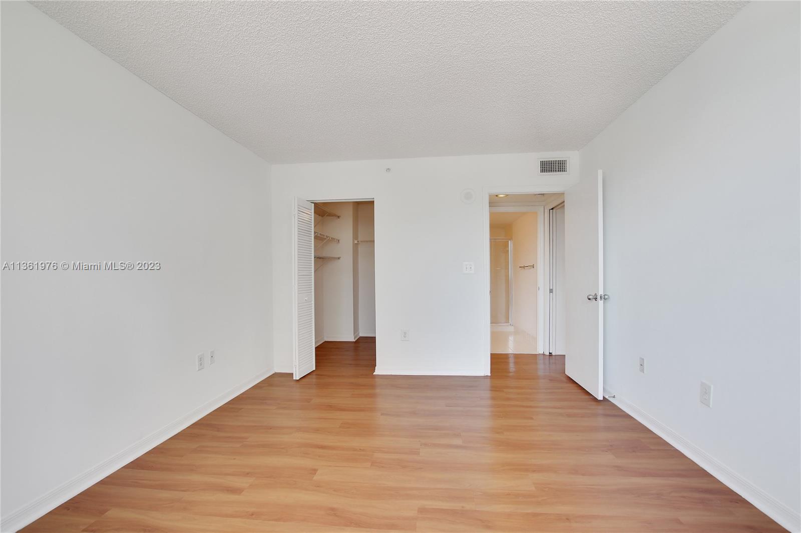 1111 Brickell Bay Drive, Unit 1102 Miami, FL 33131 - Photo 33 of 72 a view of an empty room with wooden floor and closet