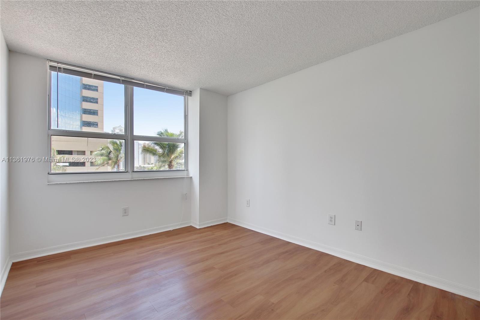1111 Brickell Bay Drive, Unit 1102 Miami, FL 33131 - Photo 34 of 72 an empty room with wooden floor and windows