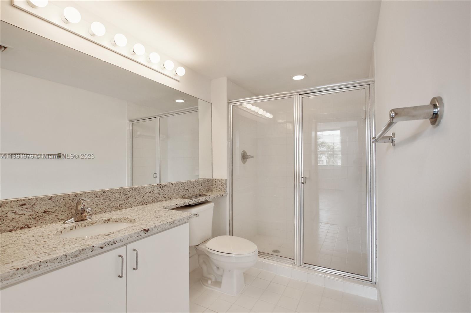 1111 Brickell Bay Drive, Unit 1102 Miami, FL 33131 - Photo 37 of 72 a bathroom with a granite countertop sink mirror vanity and toilet