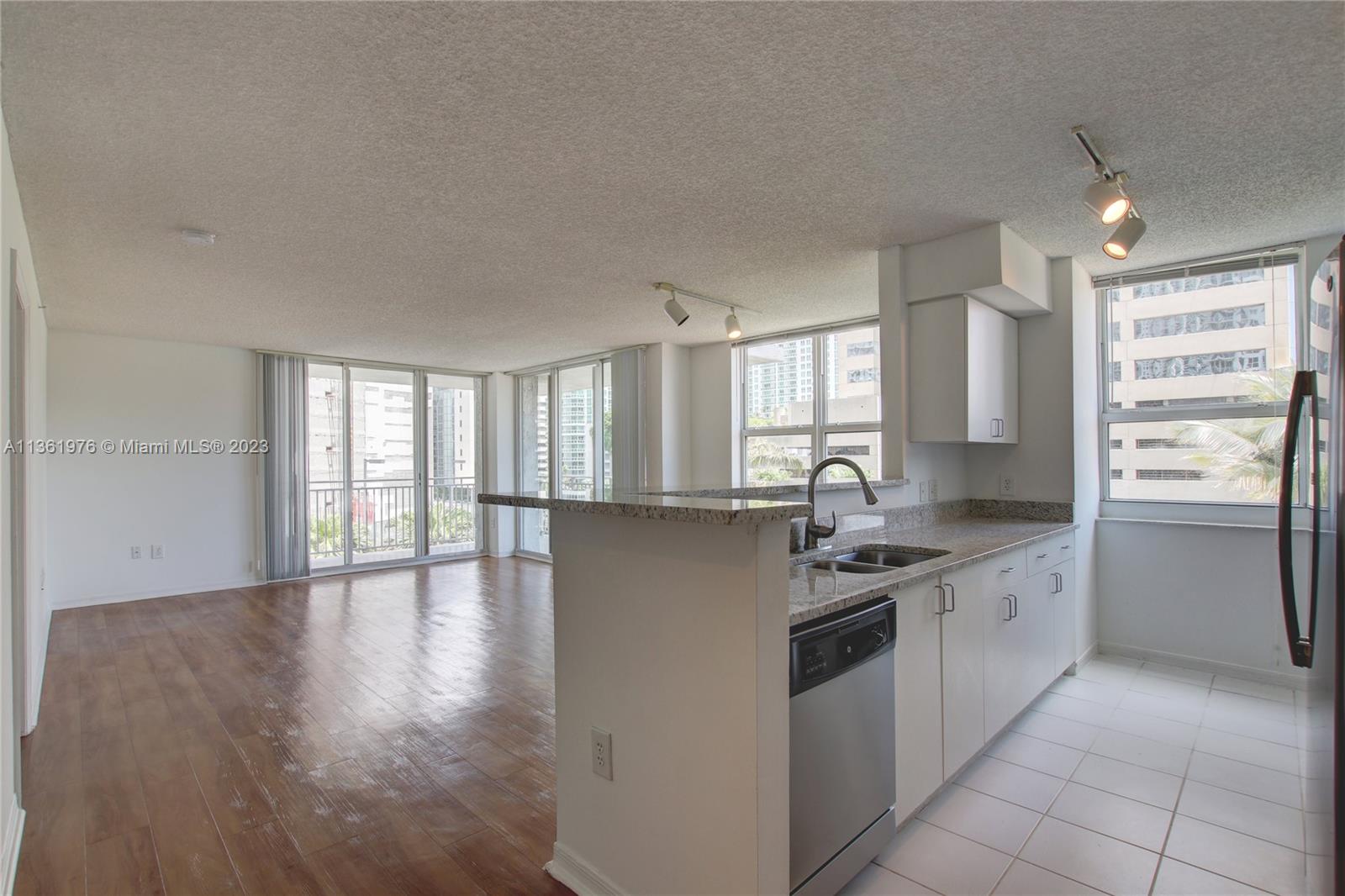 1111 Brickell Bay Drive, Unit 1102 Miami, FL 33131 - Photo 6 of 72 a kitchen with stainless steel appliances granite countertop a sink stove and refrigerator