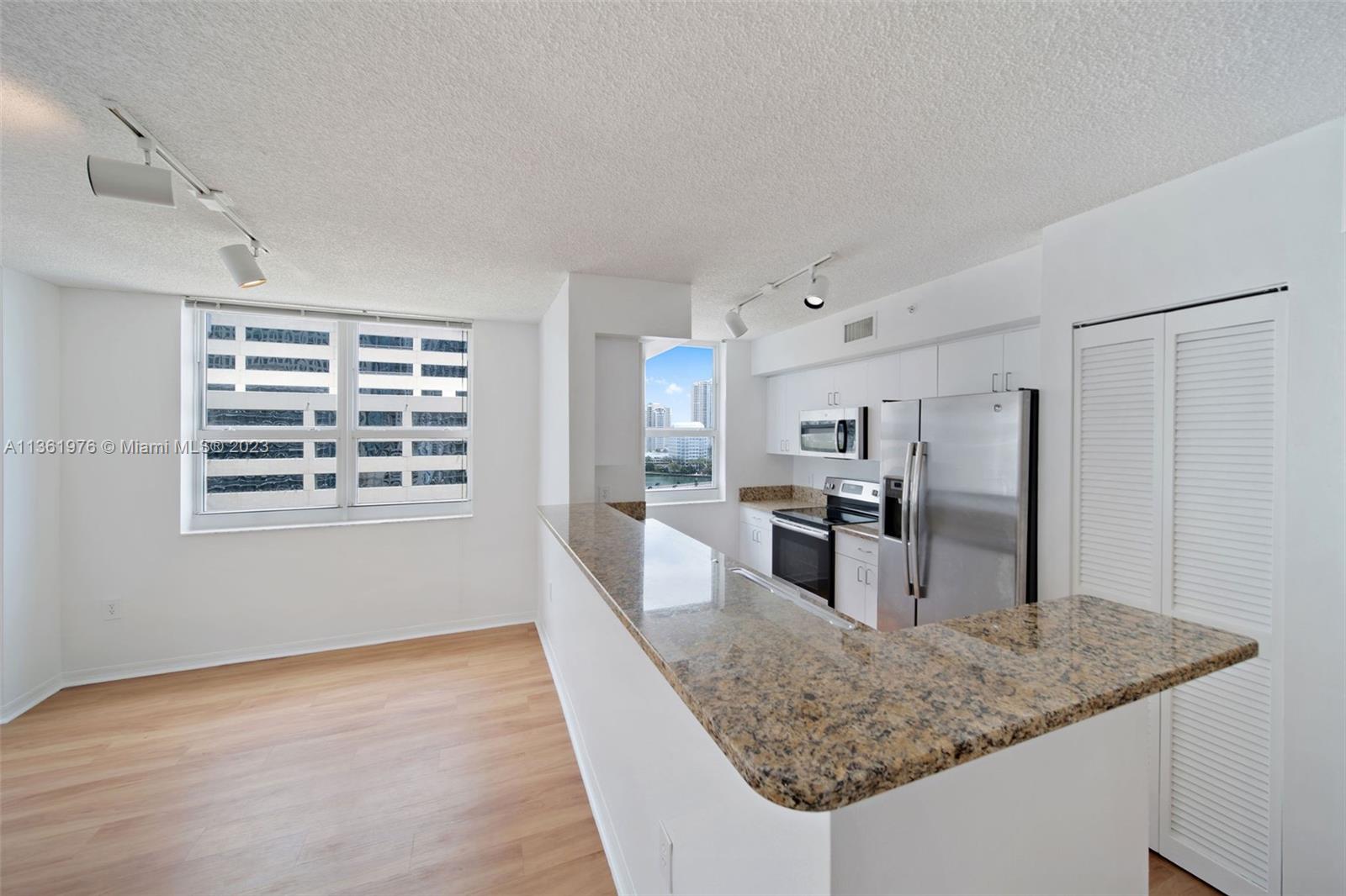 1111 Brickell Bay Drive, Unit 1102 Miami, FL 33131 - Photo 7 of 72 a kitchen with stainless steel appliances granite countertop a sink stove and refrigerator