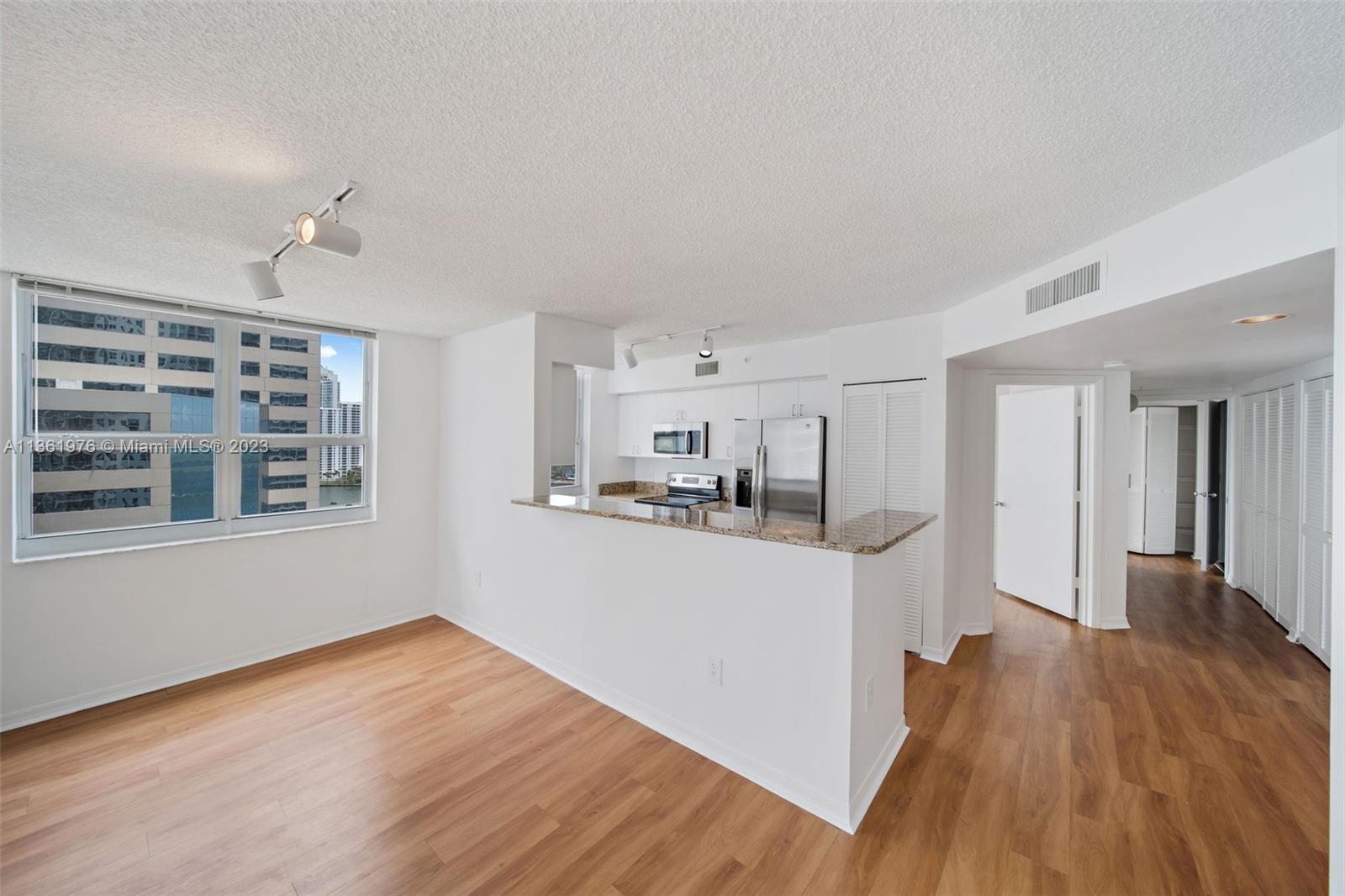 1111 Brickell Bay Drive, Unit 1102 Miami, FL 33131 - Photo 8 of 72 a kitchen with cabinets and wooden floor